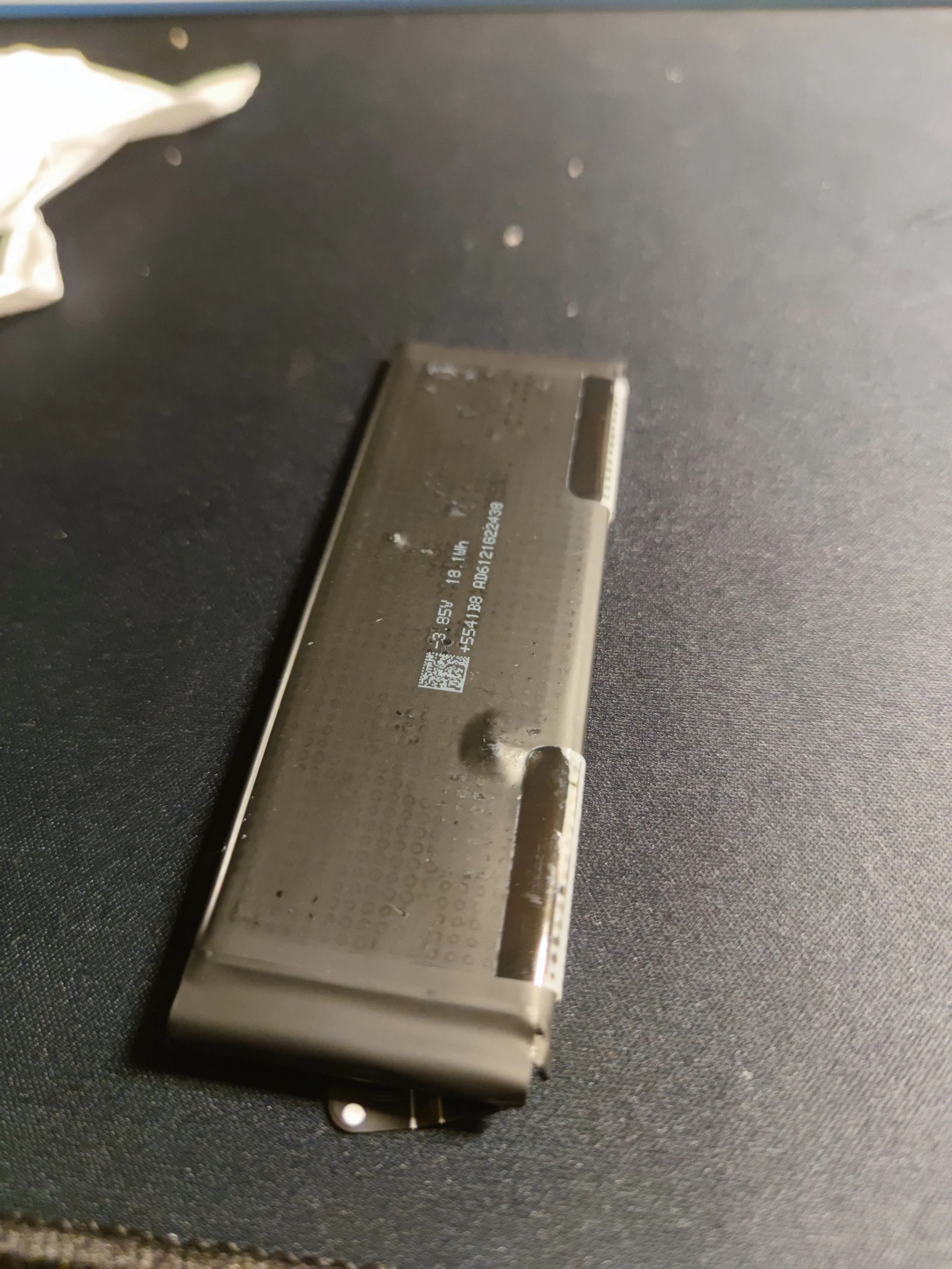 The removed old battery, already swollen